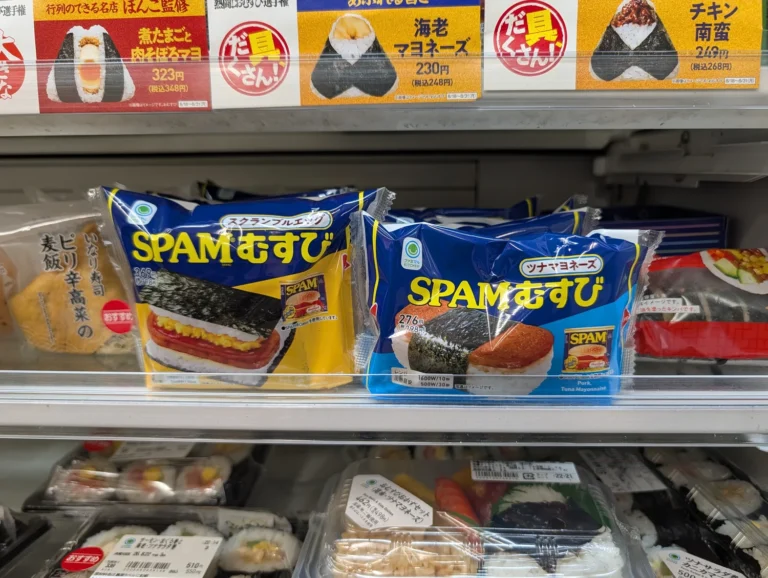 Packaged SPAM musubi rice balls on a Japanese convenience store shelf.