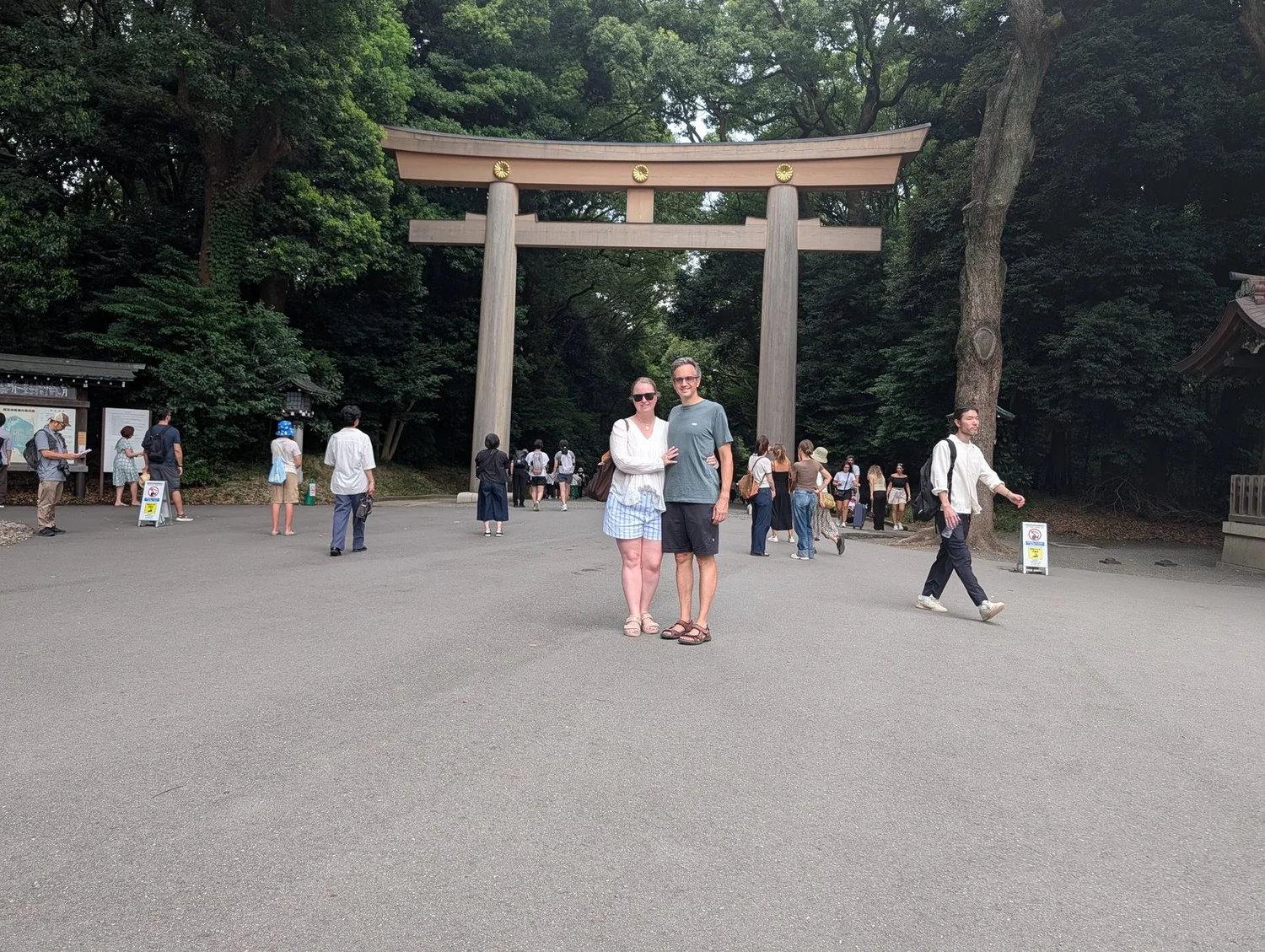 A couple standing under the great wooden torii at Meiji Jingu